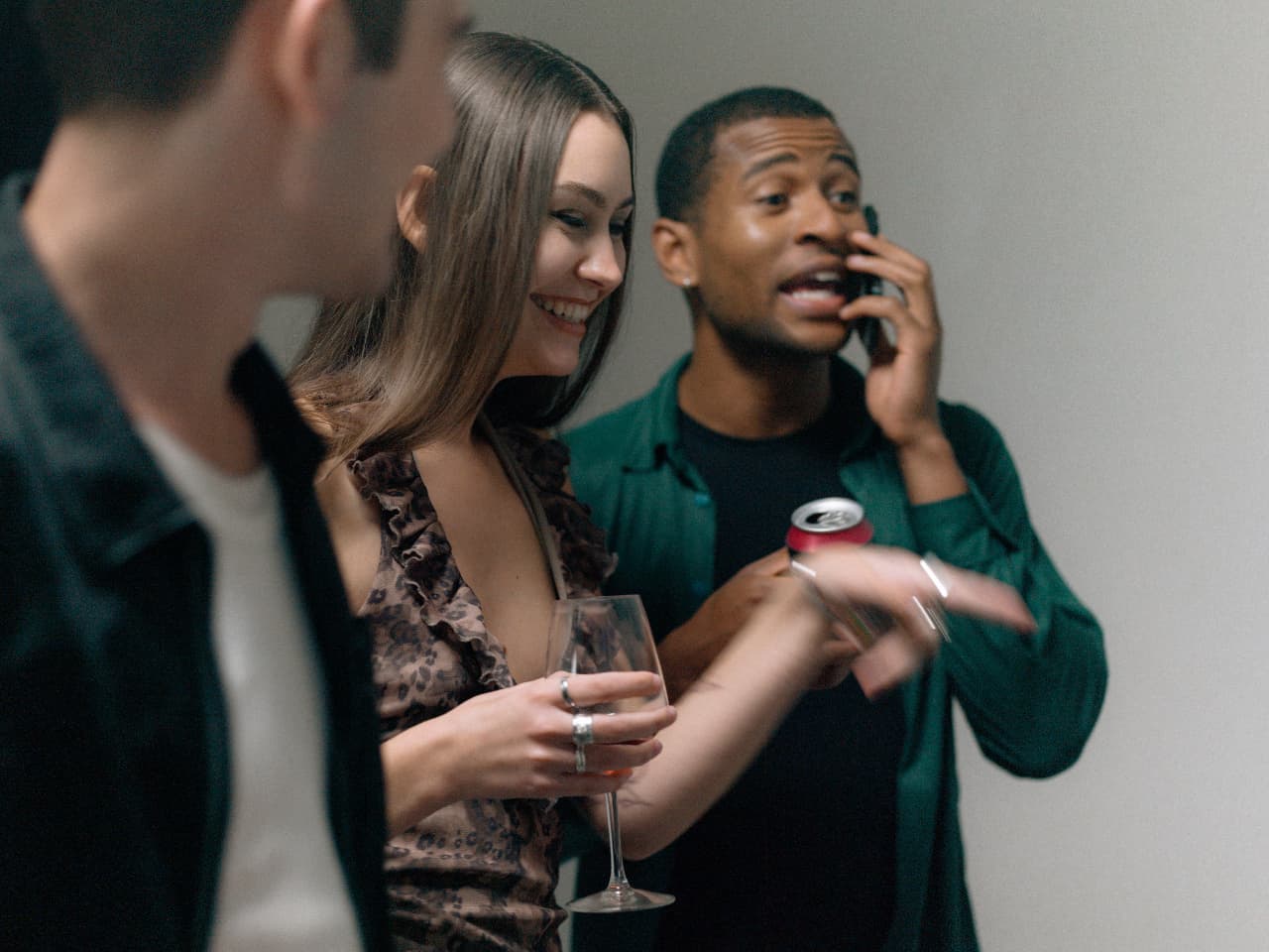 Two people talking while a third takes a call beside them