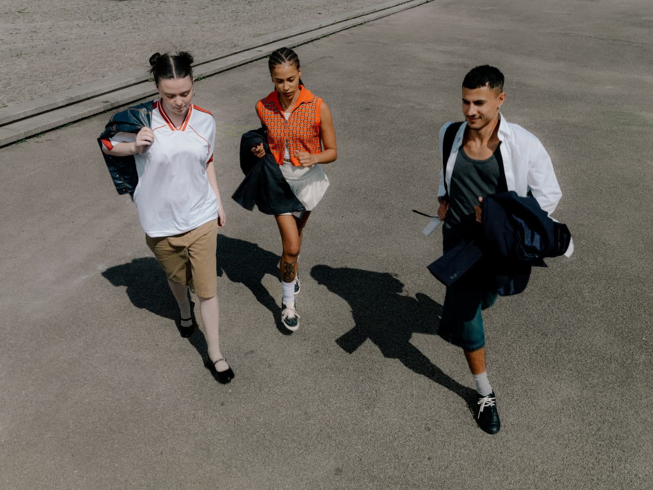 Three people walking across a square together